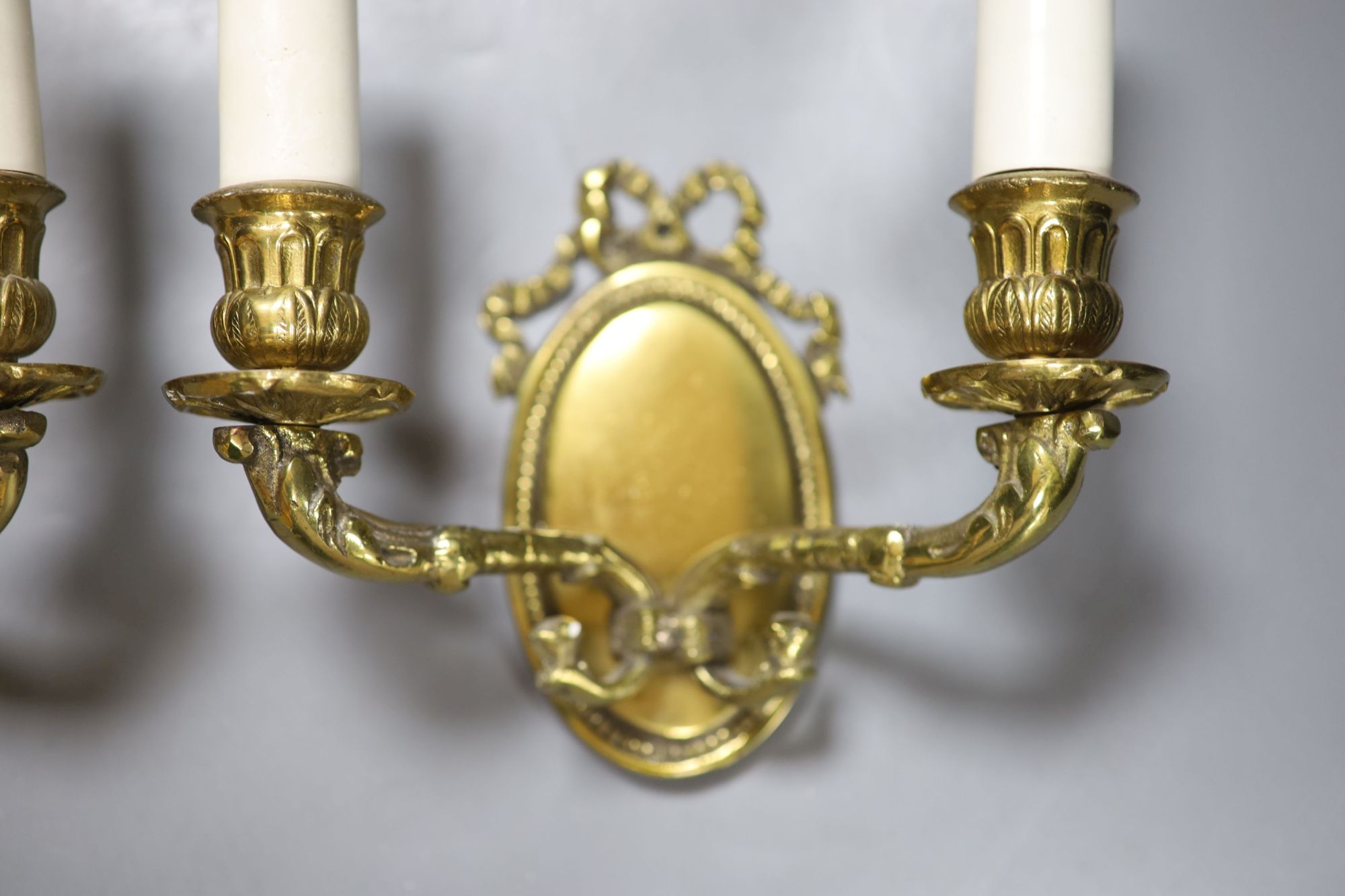 A pair of bronze two branch wall sconces, together with a South East Asian dragon door knocker